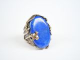 a close up of a ring with a blue stone in it