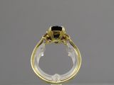 gros plan d'une bague en or contenant une pierre noire