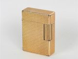 l'image d'un briquet doré posé sur une surface blanche