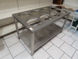 une table en acier inoxydable sur laquelle sont posés quatre plats