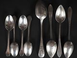 five spoons and two spoons on a black surface