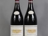 two bottles of wine sitting on top of a table next to each other
