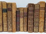 many old books lined up on a white surface