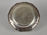 an antique silver plate sitting on a table with a white background
