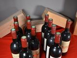 several bottles of red wine are lined up on a red cloth