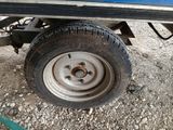 a blue truck with a flat tire parked on the side of the road