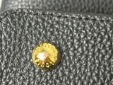 a close up of a black leather wallet with a gold button