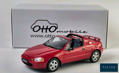 a red toy car that is sitting in front of a box