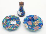 trois morceaux de verre dépoli posés sur une table, à côté d'un vase et d'une assiette