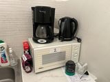 un micro-ondes et une cafetière posés sur le plan de travail d'une cuisine