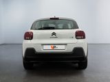 the rear end of a white citrole parked in a white room
