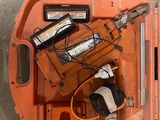 une boîte à outils orange posée par terre, contenant des outils