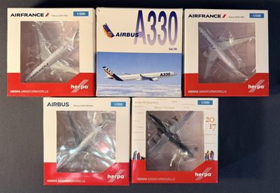 quatre maquettes d'avions posées les unes à côté des autres sur une table