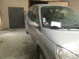 une voiture argentée garée dans un garage, avec une affiche sur le pare-brise