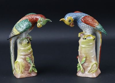 deux figurines représentant des perroquets perchés sur une souche d'arbre