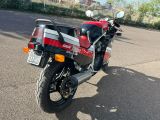 une moto rouge et noire garée sur le bord de la route
