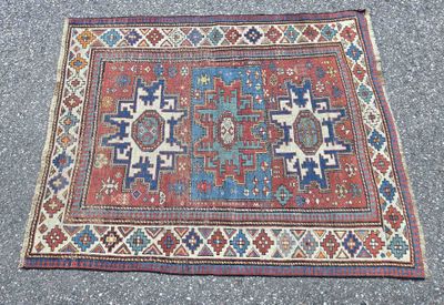 an old rug on the ground with a blue and red design