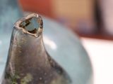 a close up of a blue vase with a hole in it