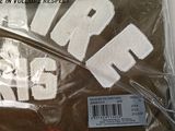 a brown shirt with white letters on it in a plastic bag