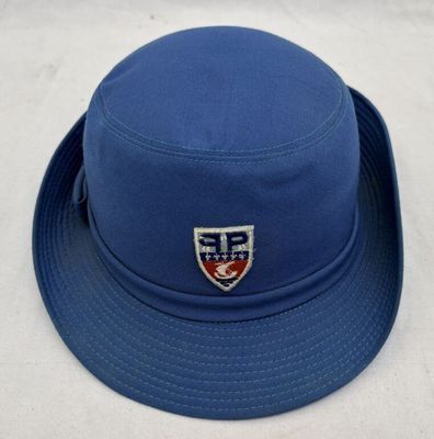 Le chapeau est bleu et est orné d'un écusson.