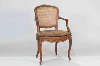 a wooden chair with a cane back and a brown seat