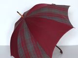un parapluie rouge et gris posé sur une surface blanche