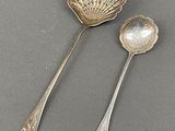 two spoons and a spoon rest on a gray surface