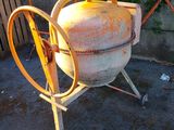 a cement mixer that is sitting on the ground