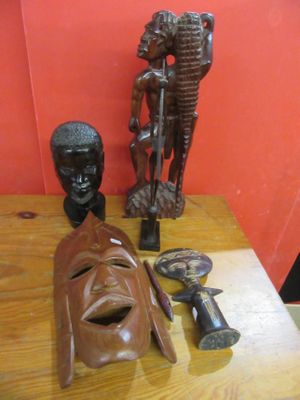 a wooden table topped with a wooden mask and other items