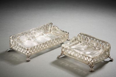 two silver plated trays with handles and handles on a table