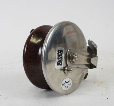 a metal object with a wooden handle on a white surface