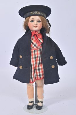 a doll that is wearing a hat and coat