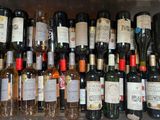 many bottles of wine sitting on a shelf together