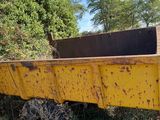 a yellow dump truck that is parked on the side of the road