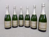 six bouteilles de champagne alignées sur une table
