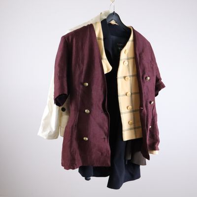 an image of a coat hanging on a hanger on a white wall