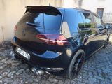 a black car that is parked on a cobblestone road