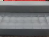 grey leather sofa and ottoman for sale at a furniture store