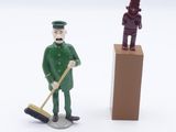 two figurines of a man with a broom and a man with a mop