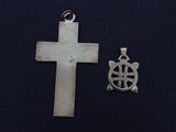two pieces of silver metal with a cross and a turtle on it