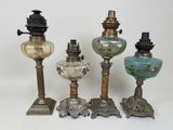 plusieurs types de lampes anciennes sont alignés sur une surface blanche