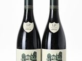 deux bouteilles de vin rouge posées l'une à côté de l'autre sur une surface blanche