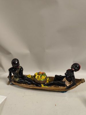 deux figurines représentant des personnes dans un bateau, posées sur une table