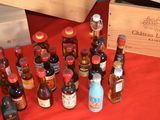 many bottles of wine on a table with a red table cloth