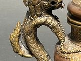 a bronze vase with a monkey on it and a lid