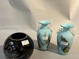 trois vases posés l'un à côté de l'autre sur une table