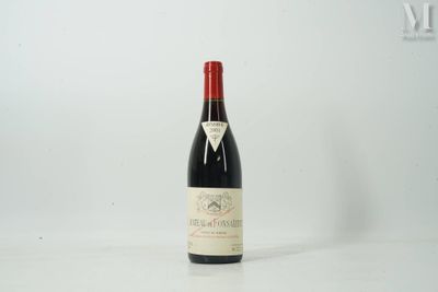 une bouteille de vin rouge posée sur une table blanche