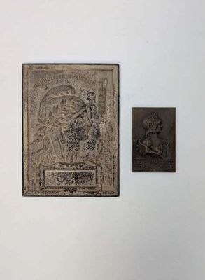 une photo d'une plaque accrochée au mur, à côté d'une autre plaque sur laquelle figure la photo d'un homme