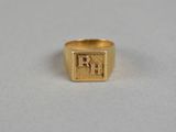 a gold signet ring with the letter rh on it