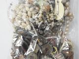 un sac contenant un assortiment de perles et de bijoux posé sur une table